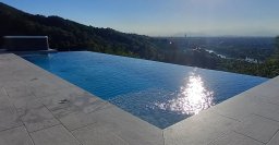 piscina acqua spa in cemento armato isolato a cascata infinity colore grigio perla con trattamento acqua ad elettrolisi salina